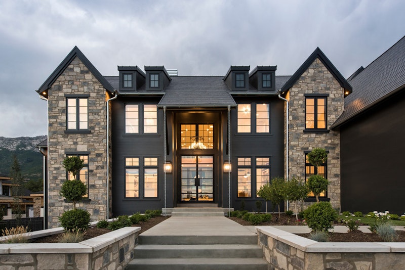 Black and stone house with Andersen A-Series windows. Photo by Andersen Windows.