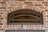 Bronze arch window with prairie grids on house with brick veneer.