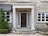 Elegant stone front entry with dark wood door, white sidelites and transom.