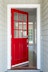 Open front door entrance featuring wood front door with red finish and grids.
