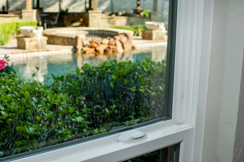 Interior close-up of single hung window with view to exterior patio.