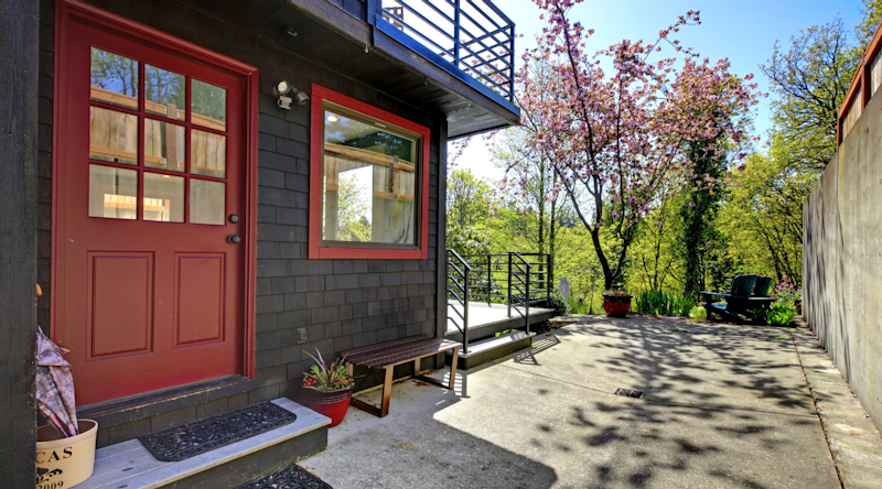 Charcoal house with red trim around the windows and doors. Photo from Adobe Stock.